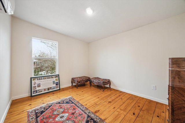 interior space with wood-type flooring and an AC wall unit