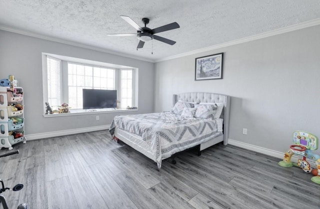 bedroom with a textured ceiling, ornamental molding, wood finished floors, and baseboards