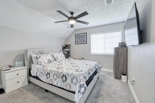 carpeted bedroom with lofted ceiling, visible vents, ceiling fan, and a textured ceiling