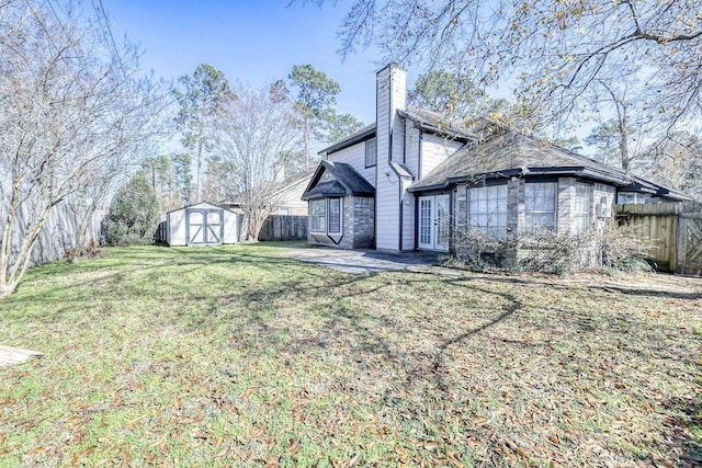 exterior space with a yard, a fenced backyard, an outdoor structure, and a storage unit