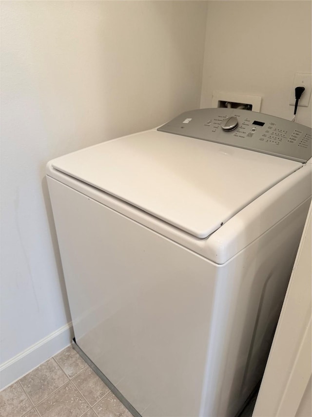 clothes washing area featuring washer / dryer and light tile patterned floors