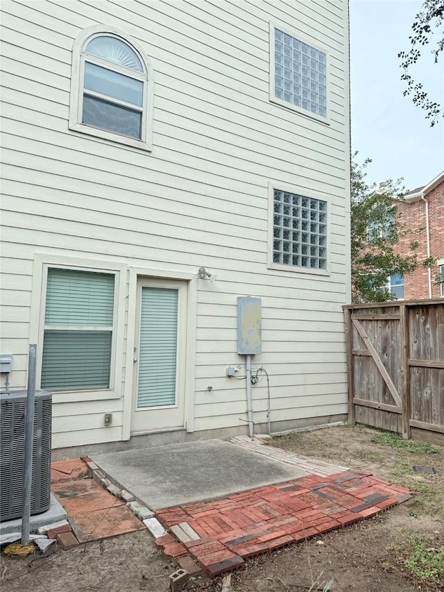 rear view of house with central AC unit and a patio area