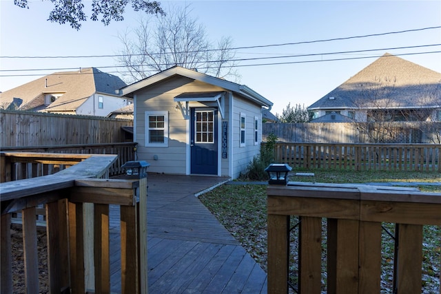 back of property with a wooden deck and an outdoor structure