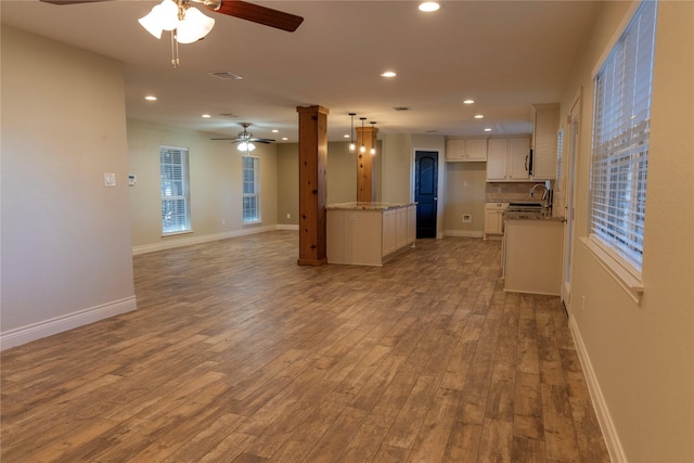 unfurnished living room featuring ceiling fan, sink, and light hardwood / wood-style floors