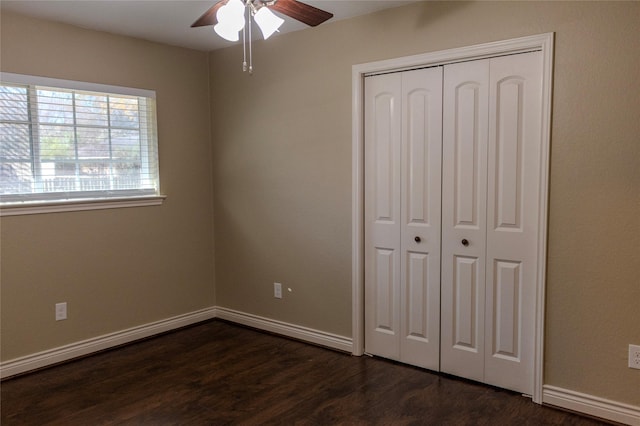 unfurnished bedroom with ceiling fan, dark hardwood / wood-style floors, and a closet