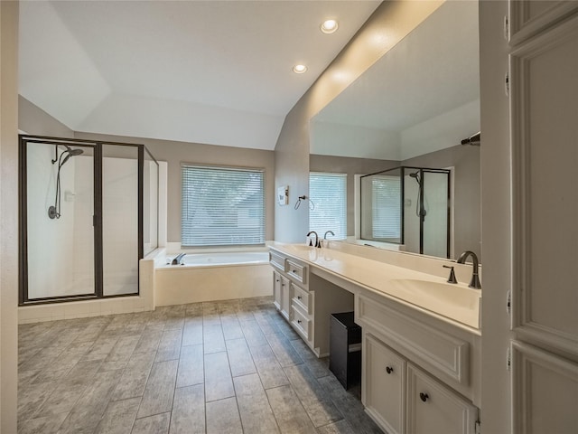 bathroom featuring vanity, vaulted ceiling, and shower with separate bathtub