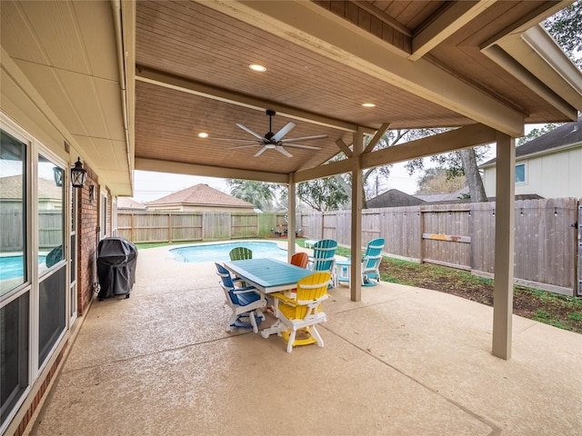 view of patio featuring ceiling fan, grilling area, and a fenced in pool