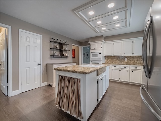 kitchen featuring white cabinetry, white appliances, a center island, and hardwood / wood-style flooring