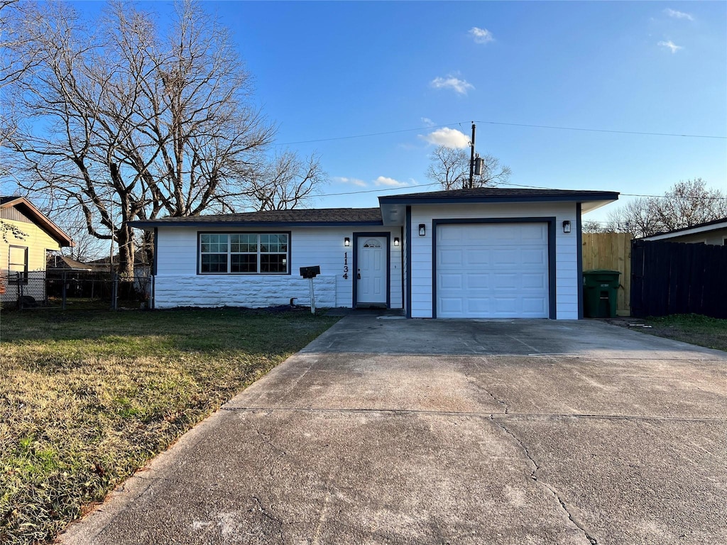 ranch-style home featuring a garage and a front lawn