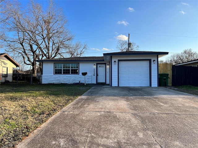 ranch-style home featuring a garage and a front lawn