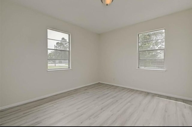 spare room with a wealth of natural light and light wood-type flooring