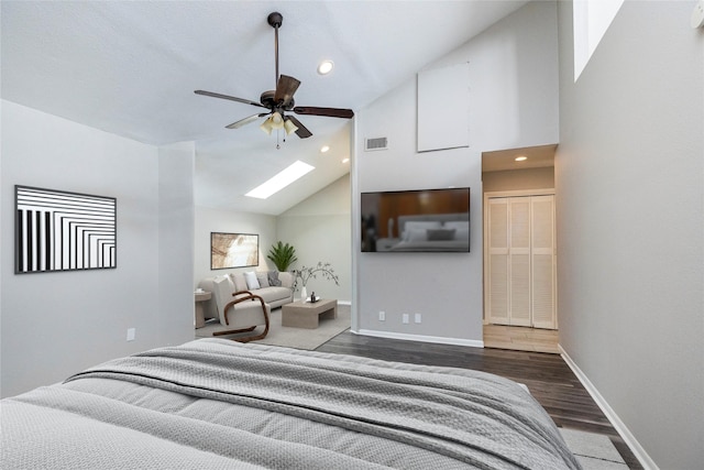 bedroom with dark hardwood / wood-style flooring, a skylight, high vaulted ceiling, and ceiling fan