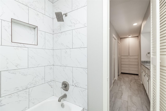 bathroom featuring tiled shower / bath combo and vanity