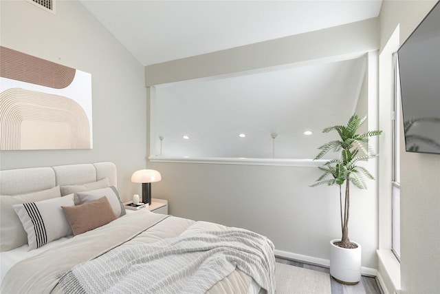 bedroom with hardwood / wood-style flooring and lofted ceiling