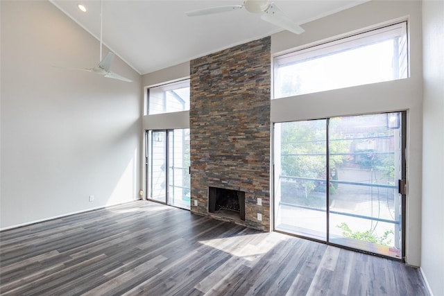 unfurnished living room with a stone fireplace, dark wood-type flooring, high vaulted ceiling, and ceiling fan