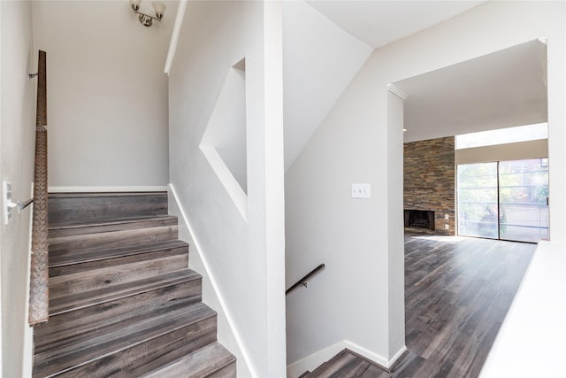 stairs with hardwood / wood-style floors and a fireplace