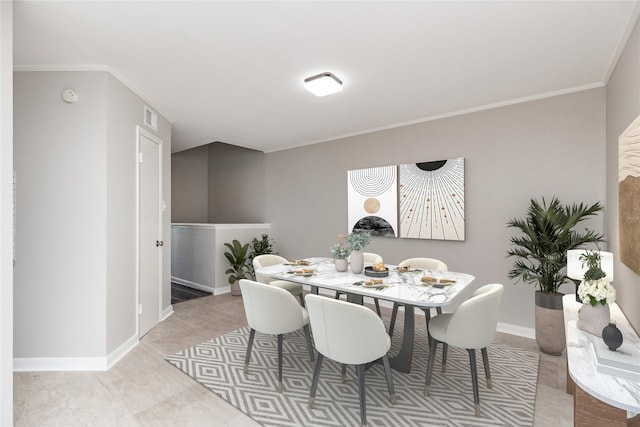 dining space featuring crown molding and light tile patterned floors