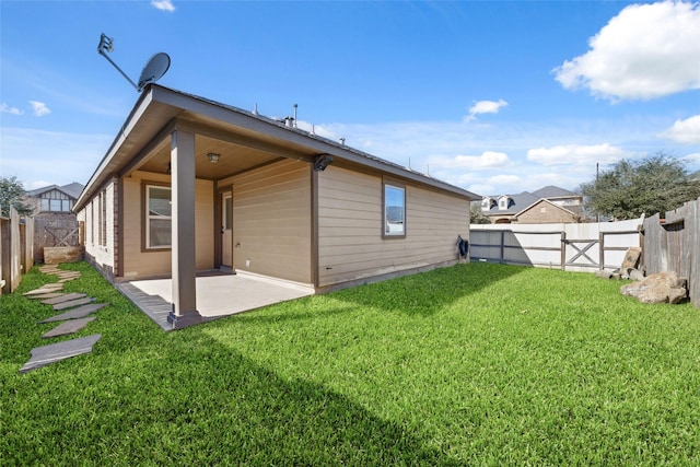 rear view of house with a yard and a patio