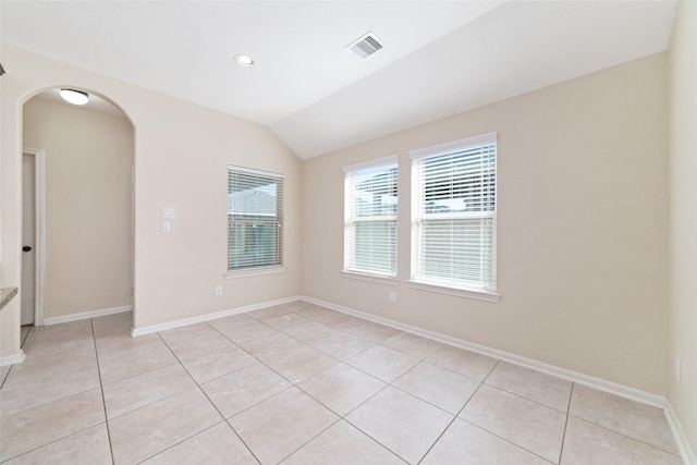 empty room featuring lofted ceiling and light tile patterned floors