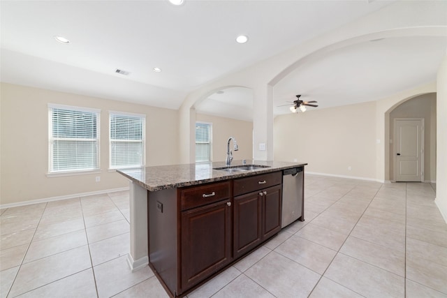 kitchen featuring stone countertops, sink, dishwasher, an island with sink, and light tile patterned flooring