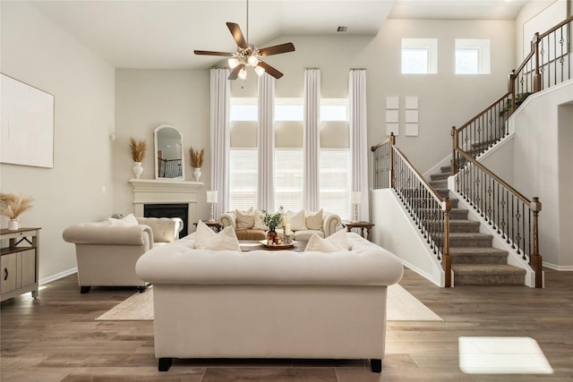 living room featuring dark hardwood / wood-style flooring, a towering ceiling, and a healthy amount of sunlight