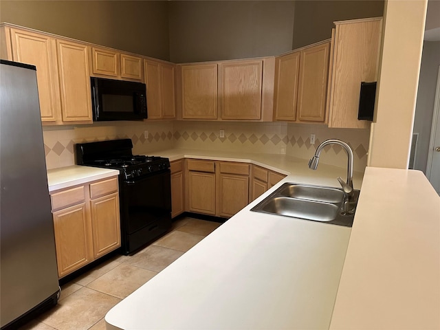 kitchen with light tile patterned flooring, sink, black appliances, light brown cabinets, and backsplash