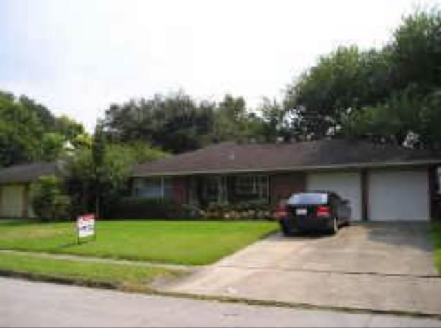 ranch-style house featuring a garage and a front yard