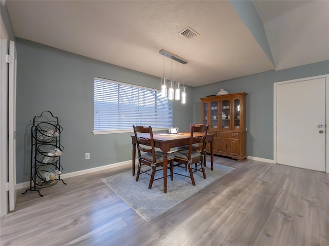 dining area featuring a notable chandelier and light wood-type flooring