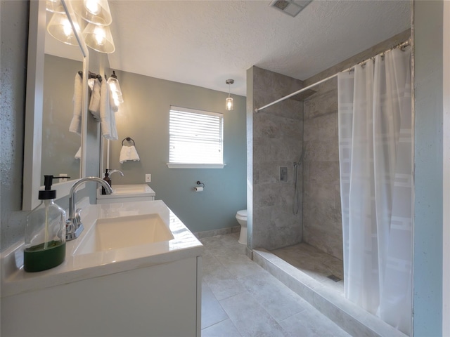 bathroom featuring tile patterned flooring, vanity, toilet, a textured ceiling, and a shower with shower curtain