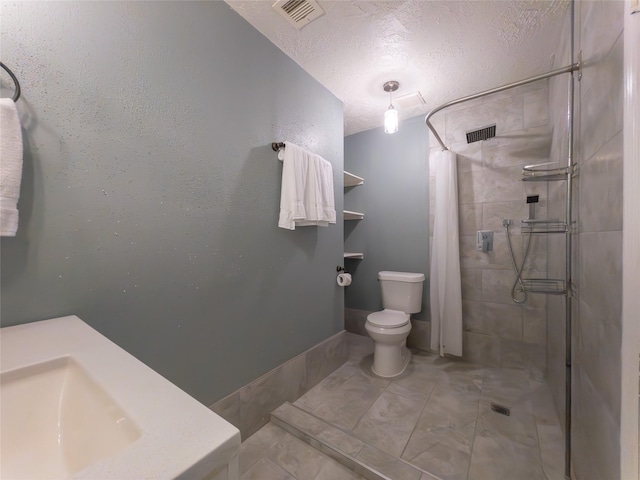 bathroom with sink, a shower with curtain, a textured ceiling, and toilet