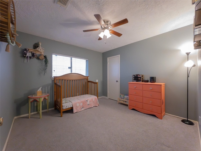 carpeted bedroom with ceiling fan and a textured ceiling