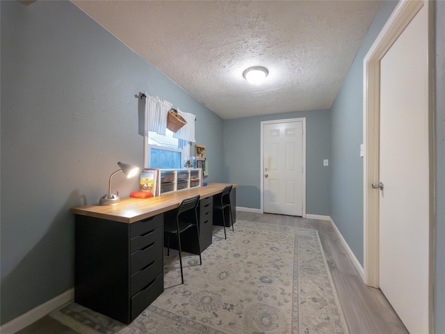 office area featuring a textured ceiling and light hardwood / wood-style floors