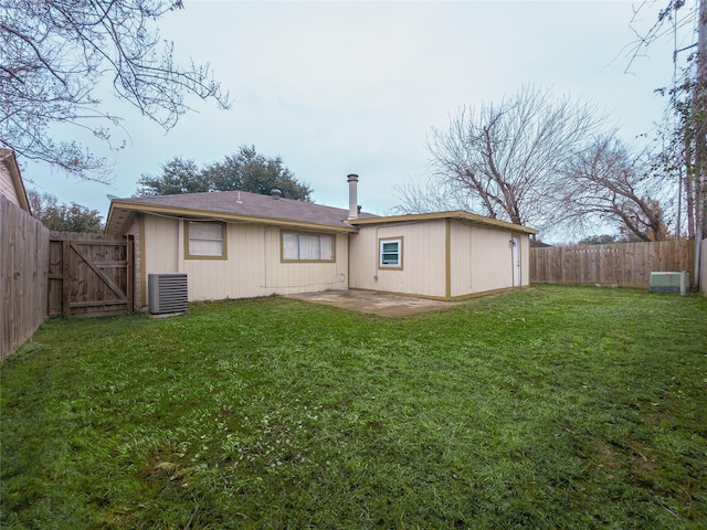 back of property featuring a lawn, central air condition unit, and a patio area