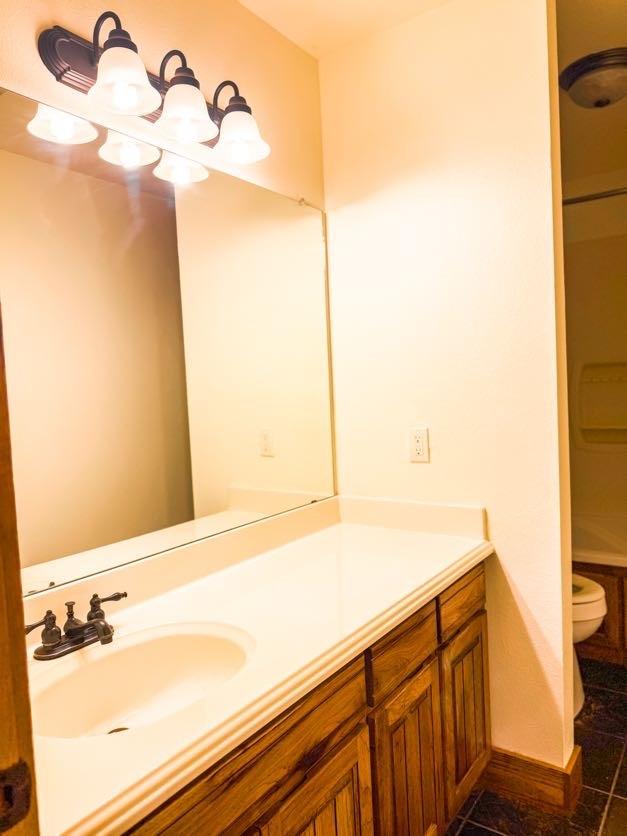 bathroom featuring tile patterned flooring, vanity, and toilet