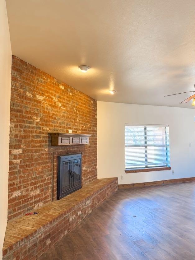 unfurnished living room with ceiling fan, a fireplace, and hardwood / wood-style floors