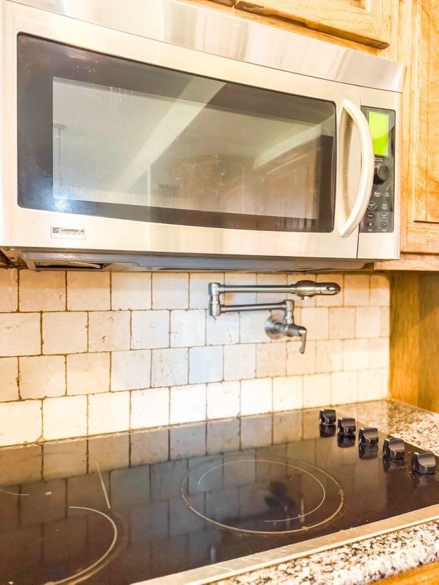 interior details with light stone counters and decorative backsplash