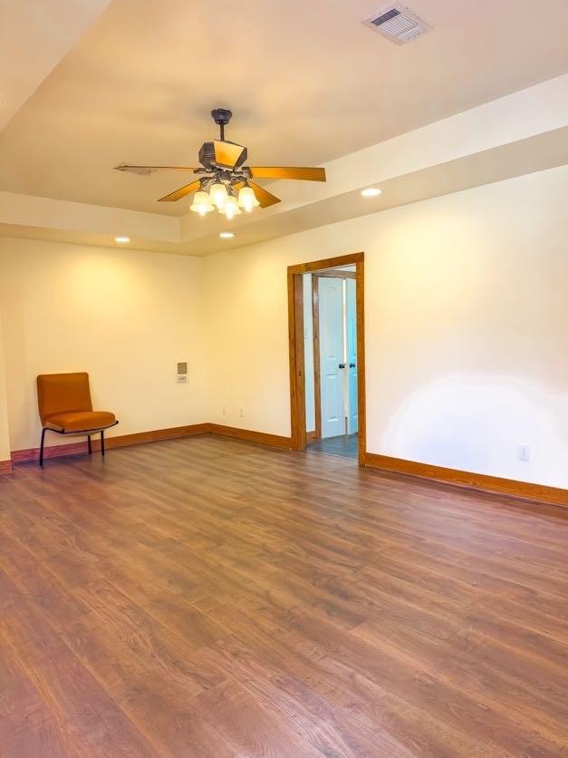 empty room featuring ceiling fan and dark hardwood / wood-style flooring