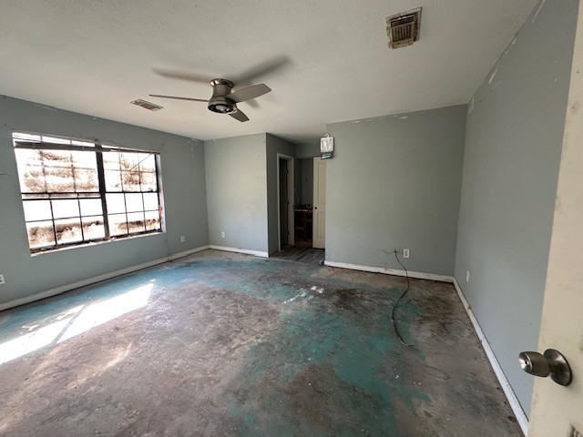 interior space with a textured ceiling and ceiling fan