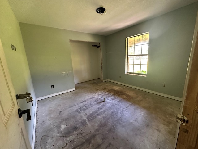 unfurnished room with concrete flooring