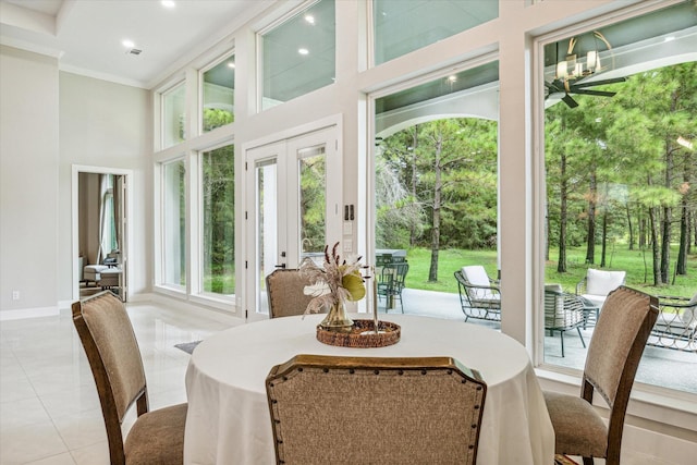 tiled dining area featuring a high ceiling, crown molding, and french doors