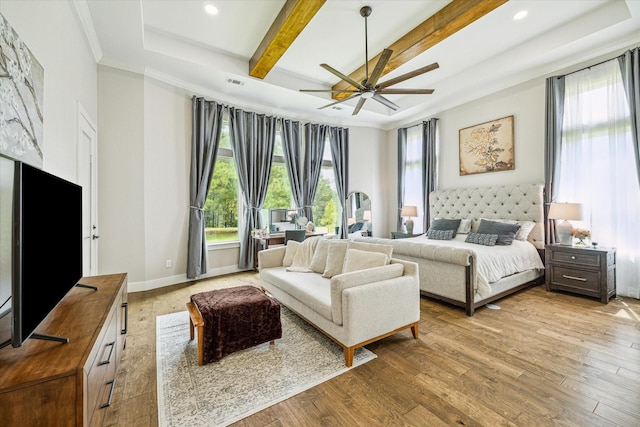 bedroom with beamed ceiling, crown molding, ceiling fan, and light hardwood / wood-style flooring