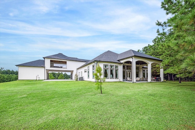 rear view of house featuring central AC, ceiling fan, a patio, and a lawn