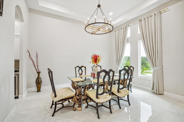 dining area featuring light tile patterned flooring and a notable chandelier