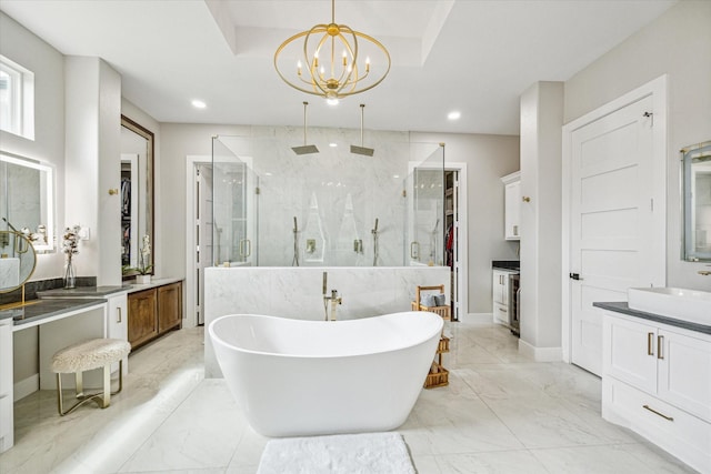 bathroom featuring a chandelier, vanity, independent shower and bath, and a raised ceiling