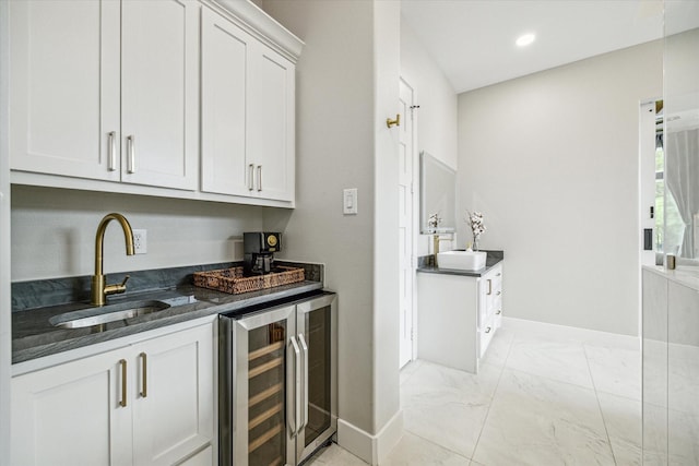 bar with white cabinets, sink, dark stone countertops, and wine cooler