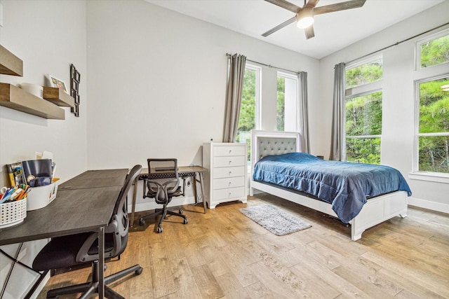 bedroom featuring multiple windows, light hardwood / wood-style flooring, and ceiling fan