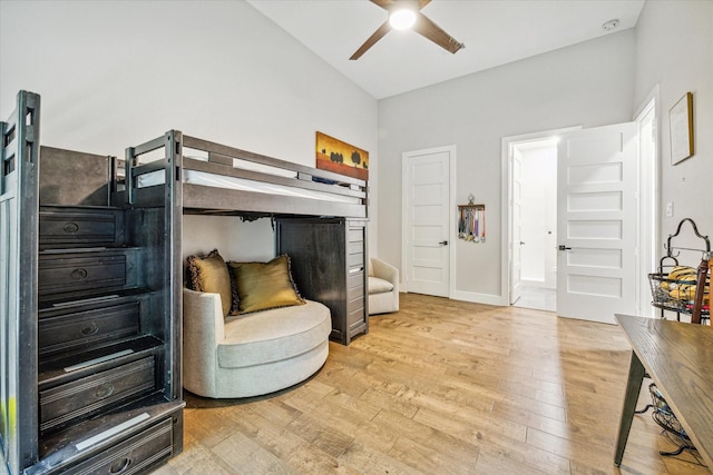 bedroom with lofted ceiling, ensuite bathroom, ceiling fan, and light wood-type flooring