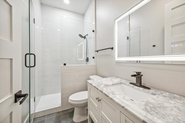 bathroom featuring vanity, toilet, tile patterned floors, and a shower with shower door