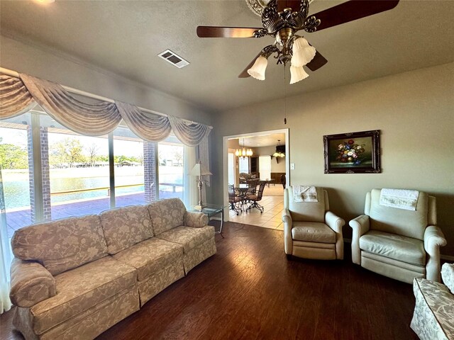 living room with hardwood / wood-style flooring, a water view, and ceiling fan