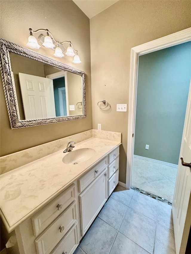 bathroom featuring tile patterned floors, baseboards, and vanity